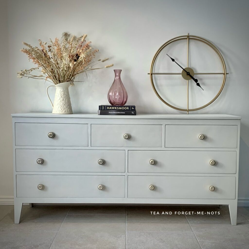 image shows neutral grey chest of drawers.