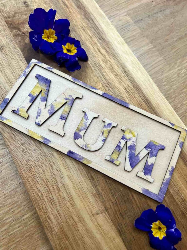 image shows mum in wooden letters with flowers.