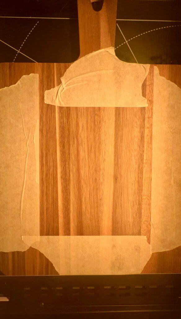 image shows chopping board with masking tape to mask off area to engrave.