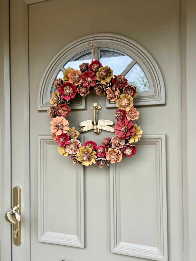 image shows painted pinecone wreath on front door.