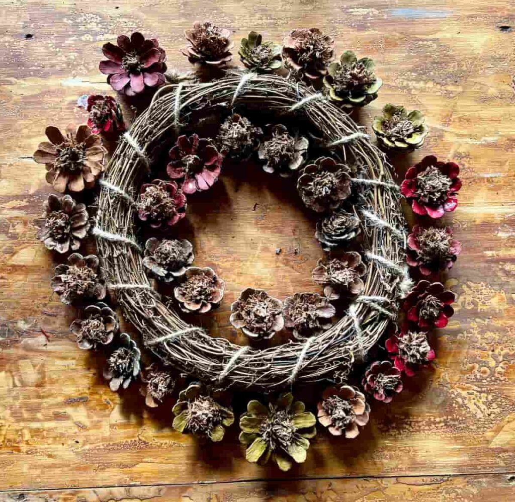 image shows wreath with pinecones around the edges.