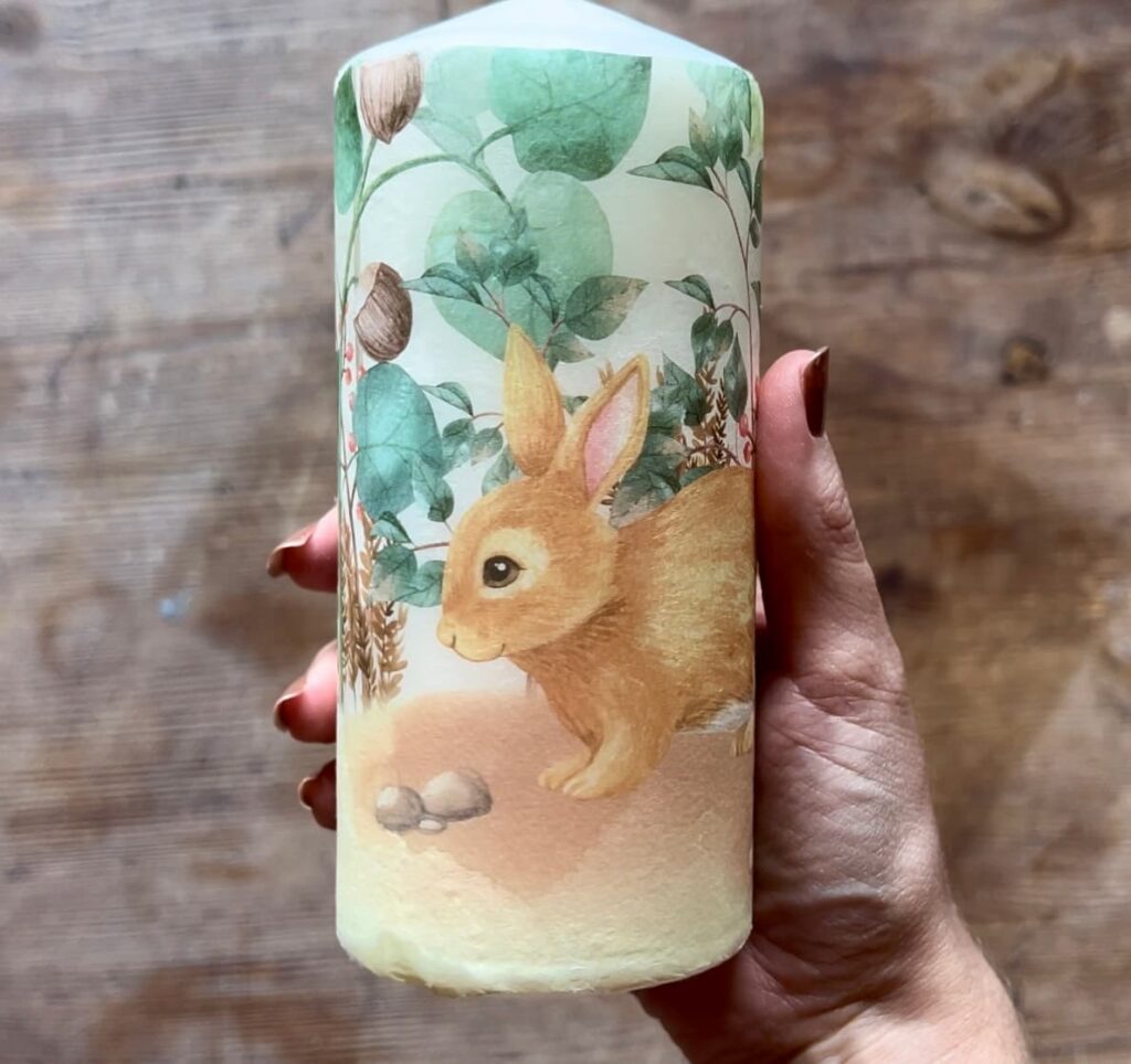 image shows wax candle with rabbit decoupage paper.