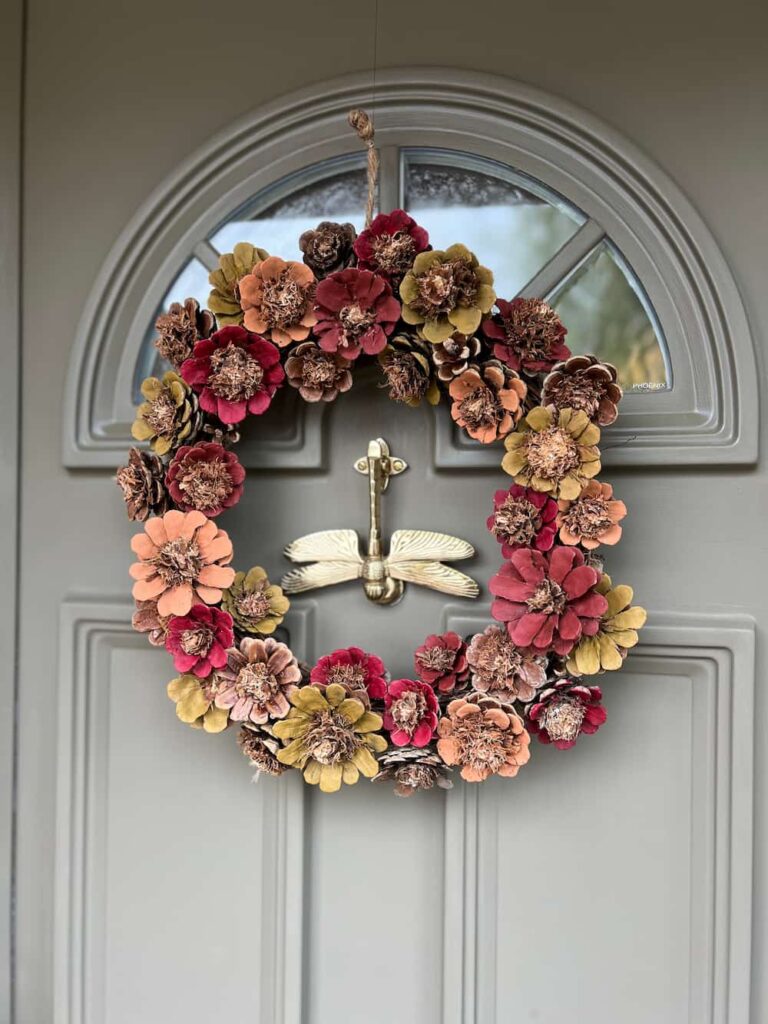 image shows painted pinecone wreath on a front door.