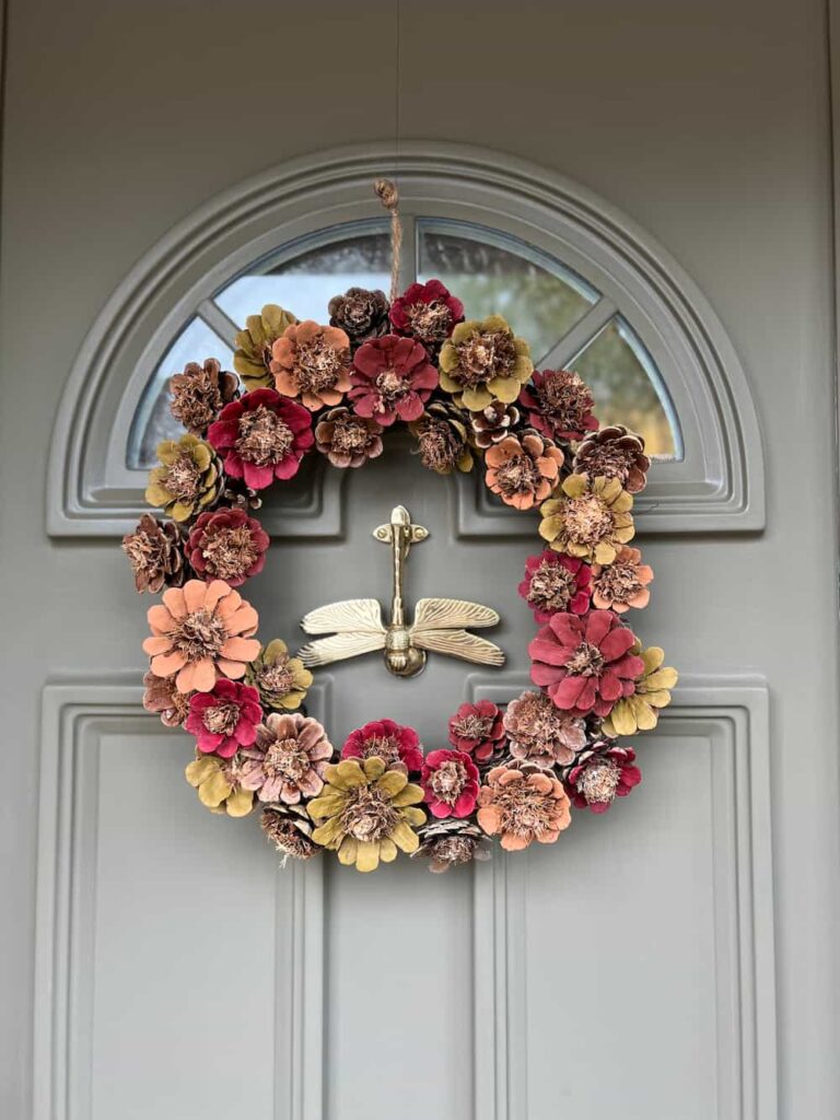 image shows painted pine cone wreath on front door.