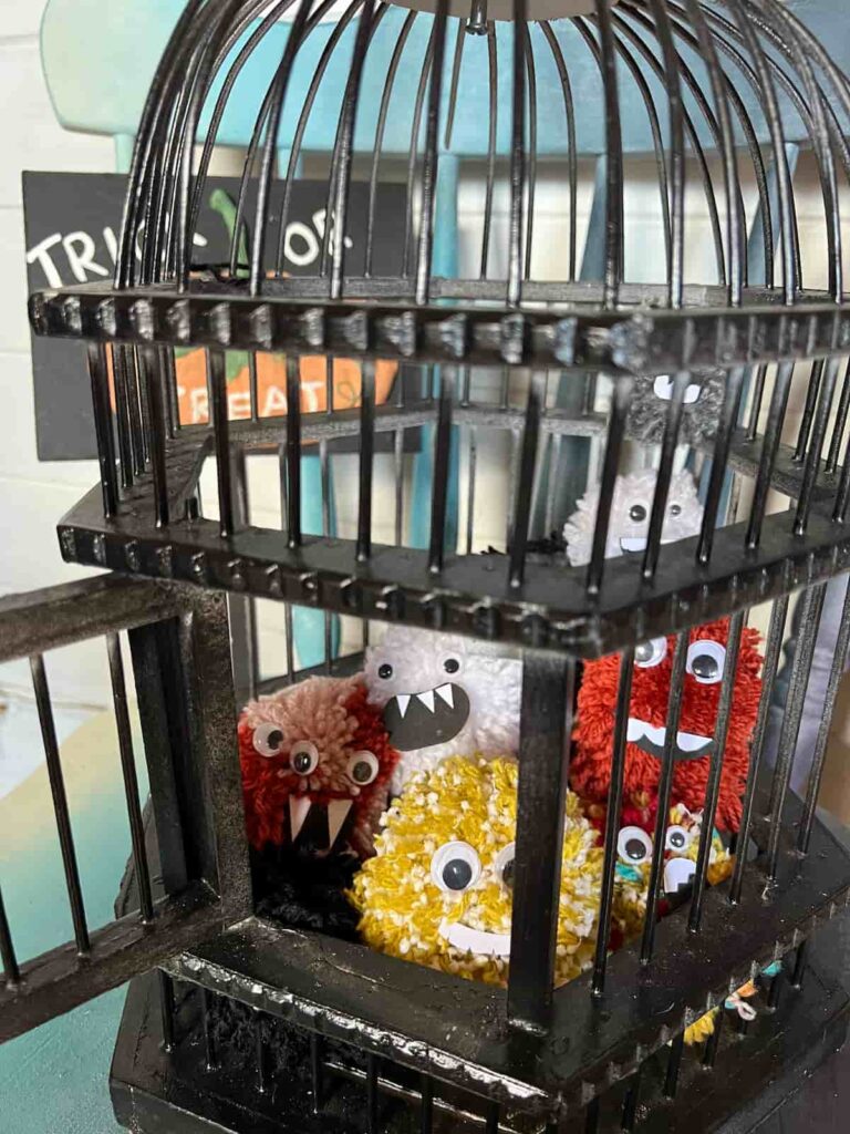 halloween monsters pompoms in a black cage.