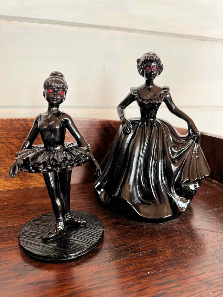 image shows two figures painted black.