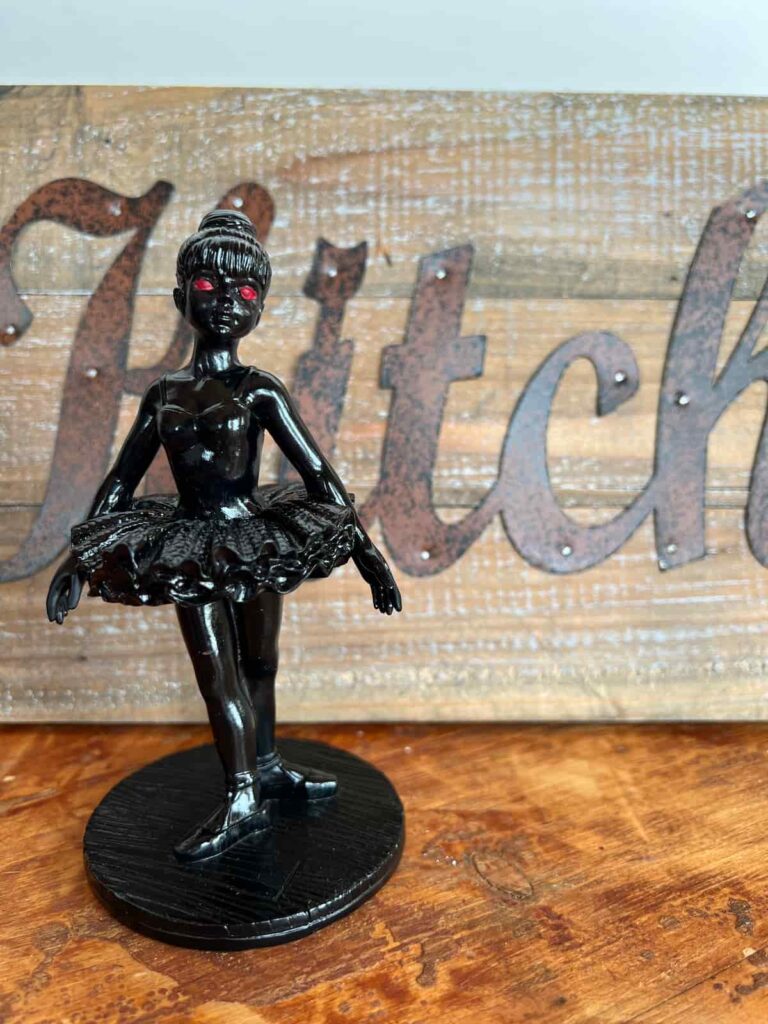 image shows ballerina figurine painted in black.