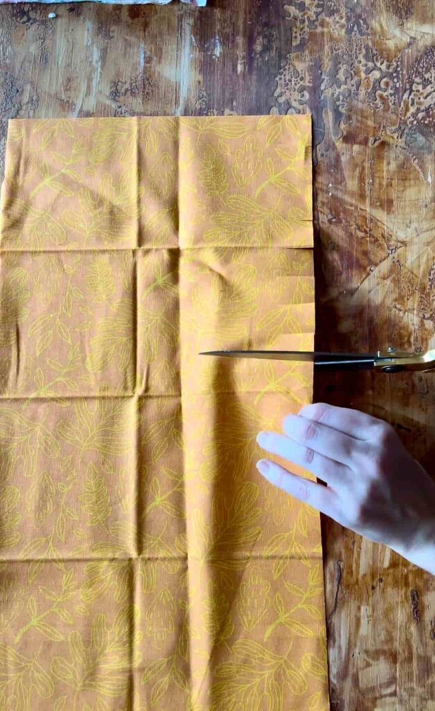 image shows cutting into fabric with scissors.