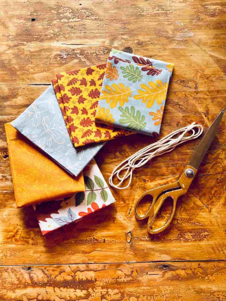 image shows fabric, scissors and string on a table.