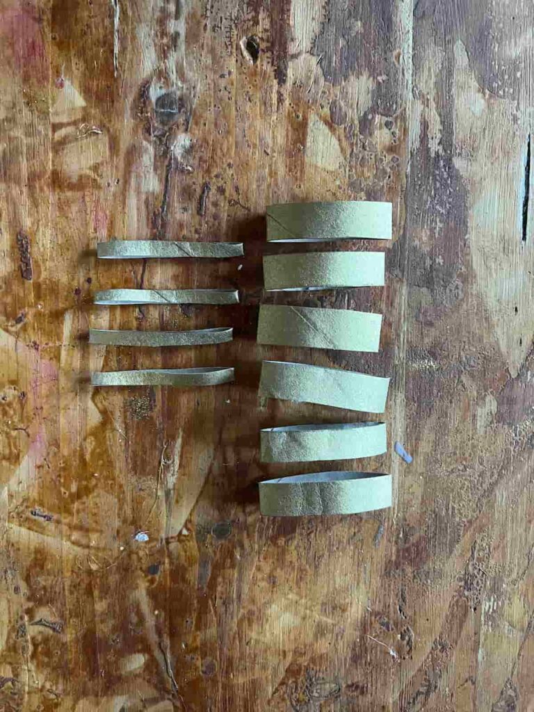 image shows gold painted toilet paper rolls cut into pieces.