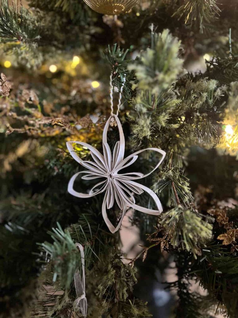 image shows white christmas tree decoration made from toilet paper toll.