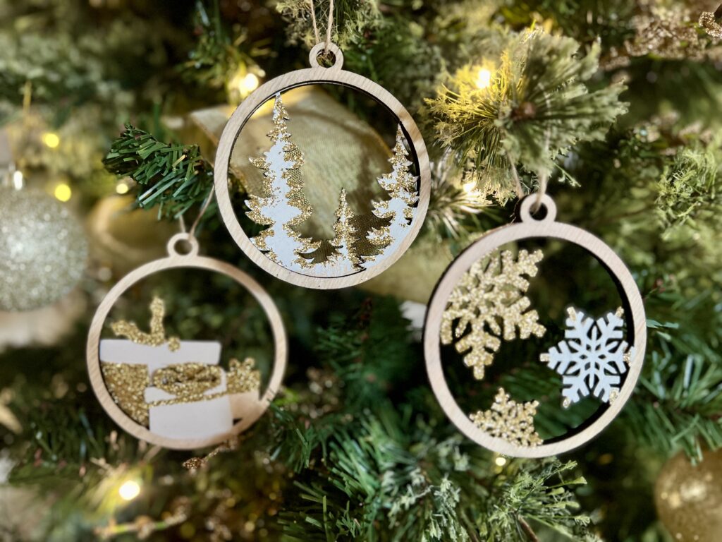 image shows three laser cut baubles on a tree.