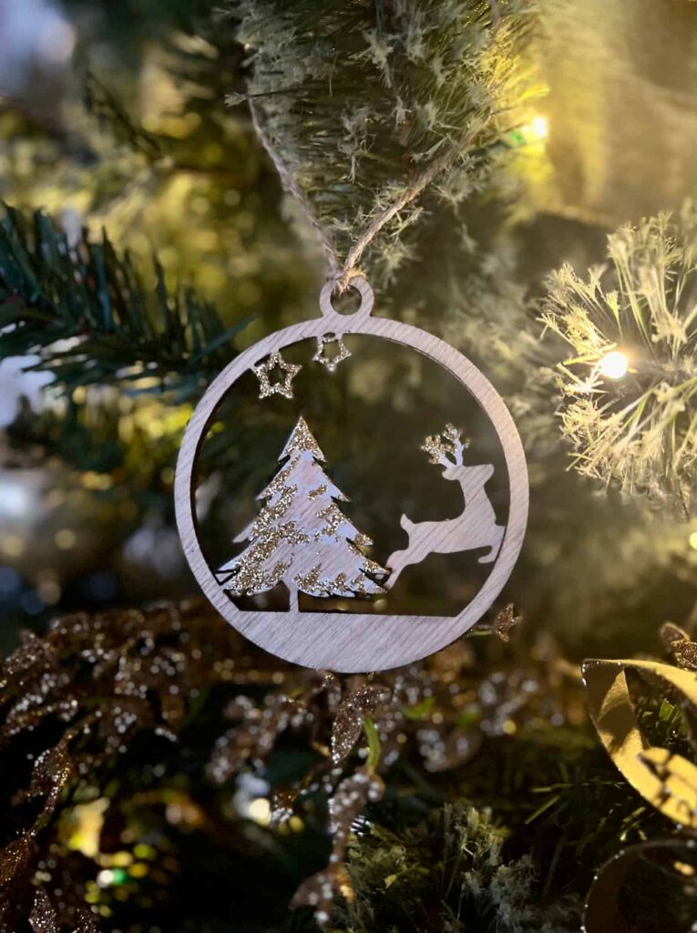 image shows reindeer and christmas tree ornament on a tree.