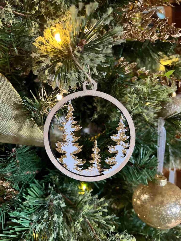 image shows laser cut tree ornament on a tree.