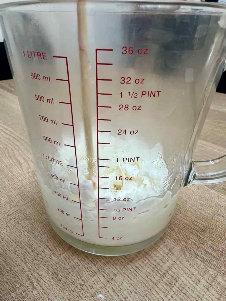 image shows soy wax flakes melting in measuring jug.