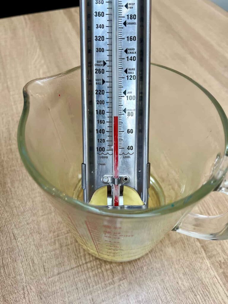 image shows thermometer in measuring jug of melted soy wax.