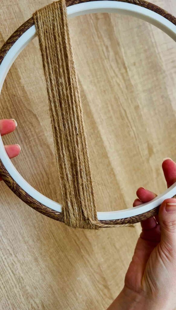 image shows string end tied off after wrapping round embroidery hoop.