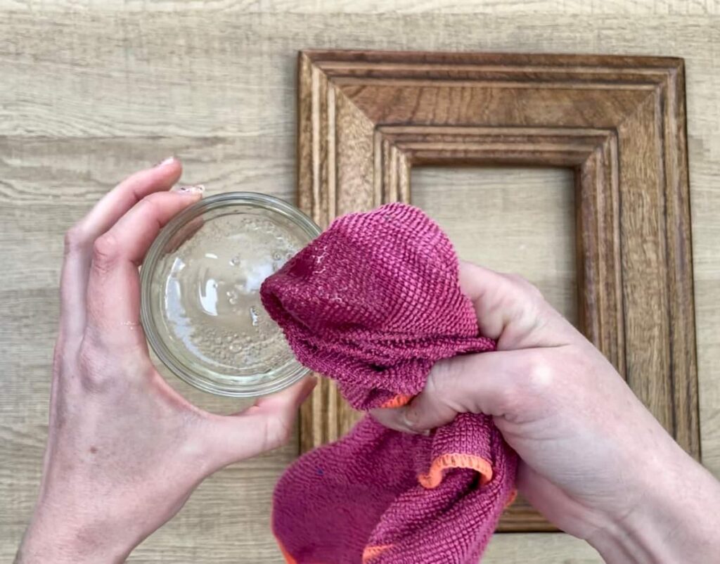 image shows oil and vinegar mixed with a pink cloth.