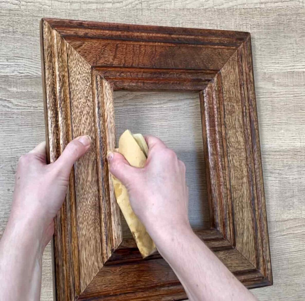 image shows sanding edge of wooden photo frame.