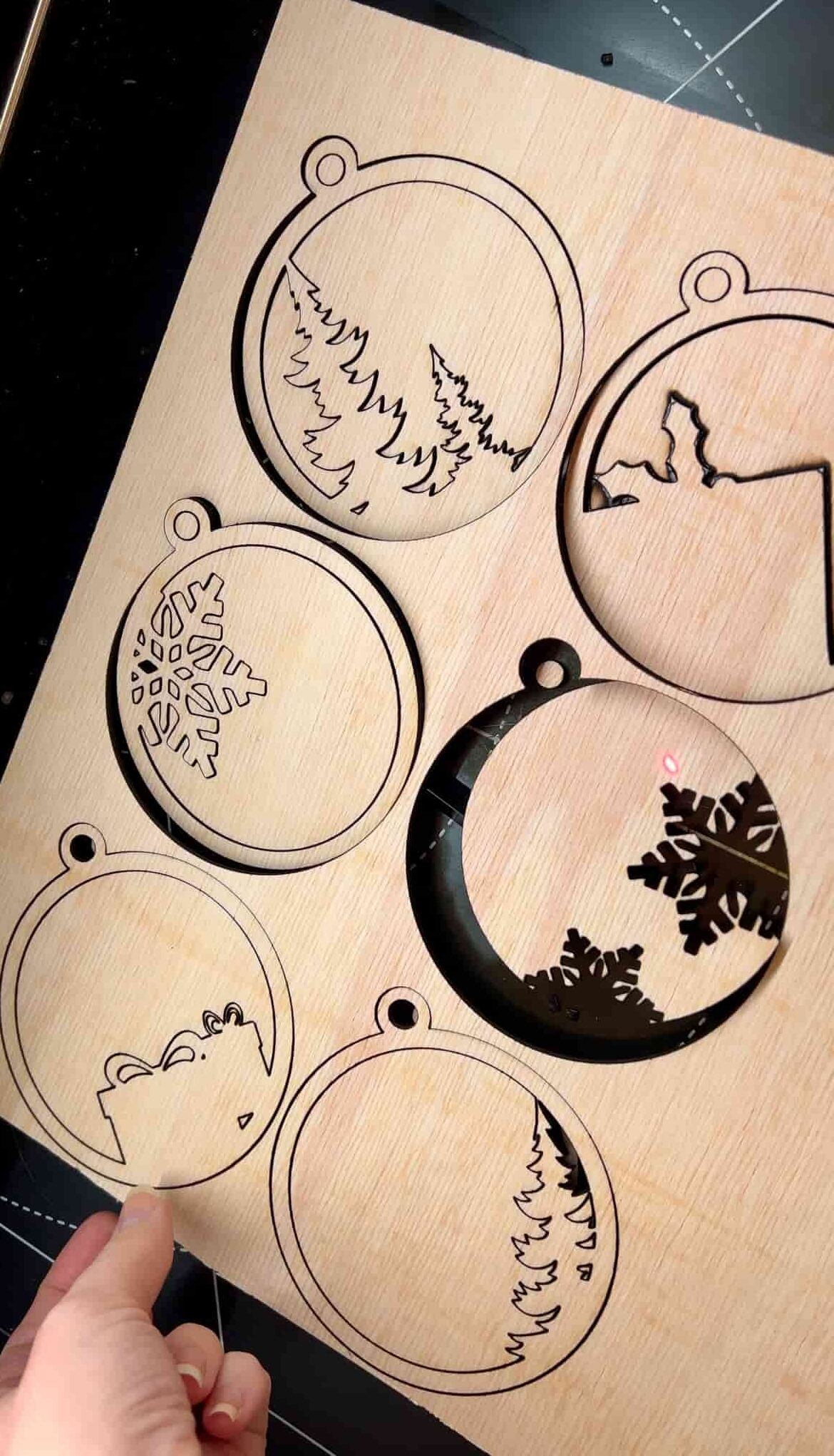 image shows laser cut ornaments after cutting on machine.