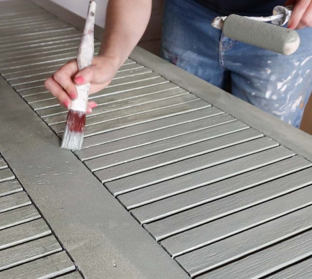 image shows painting outdoor table green with paintbrush.