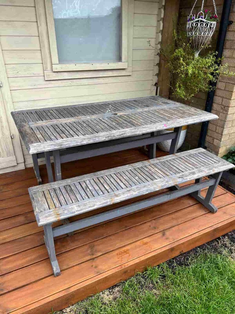 image shows a patio table on a deck before a makeover.