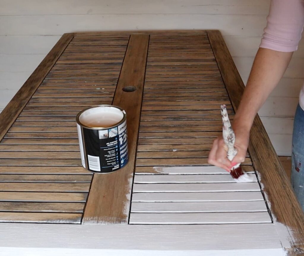 image shows painting garden table with primer.