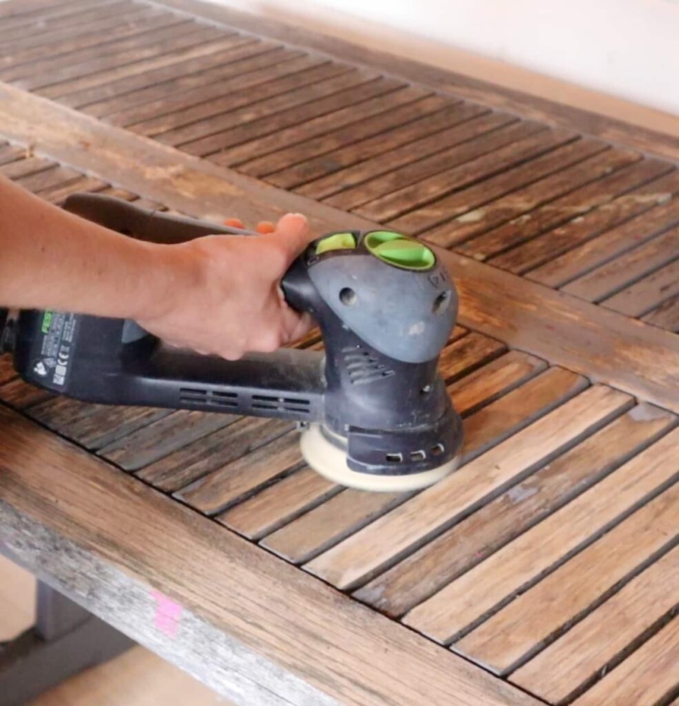 image shows sanding patio table.