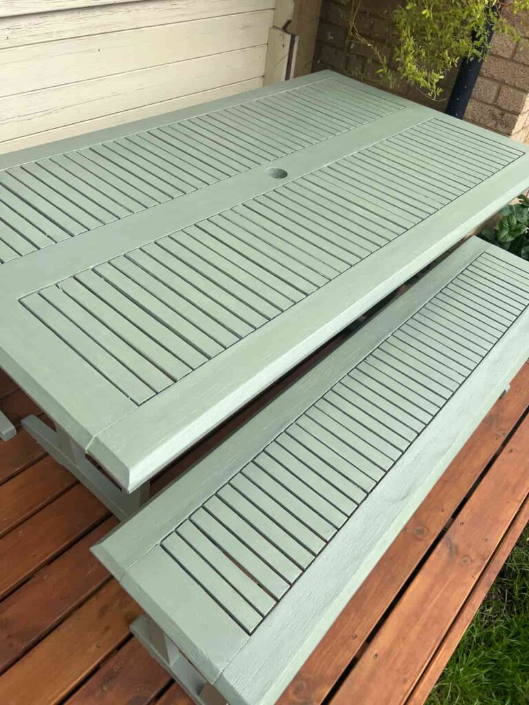 image shows green painted garden table after makeover.